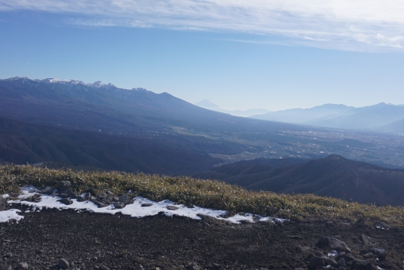 車山山頂からの景色、左に八ヶ岳連峰、中央に薄く富士山、右に南アルプスの一部の山々が見える