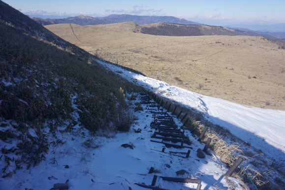 車山の北側の登山道の階段を少し下ったところ、道に雪がついて日陰で少し暗くなっている