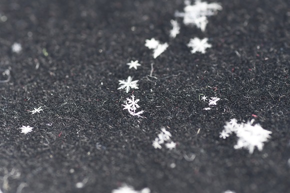 黒い布の上に落ちた白い雪の結晶