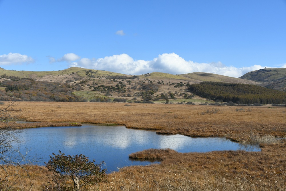 緩やかな山並みと青空を映した池
