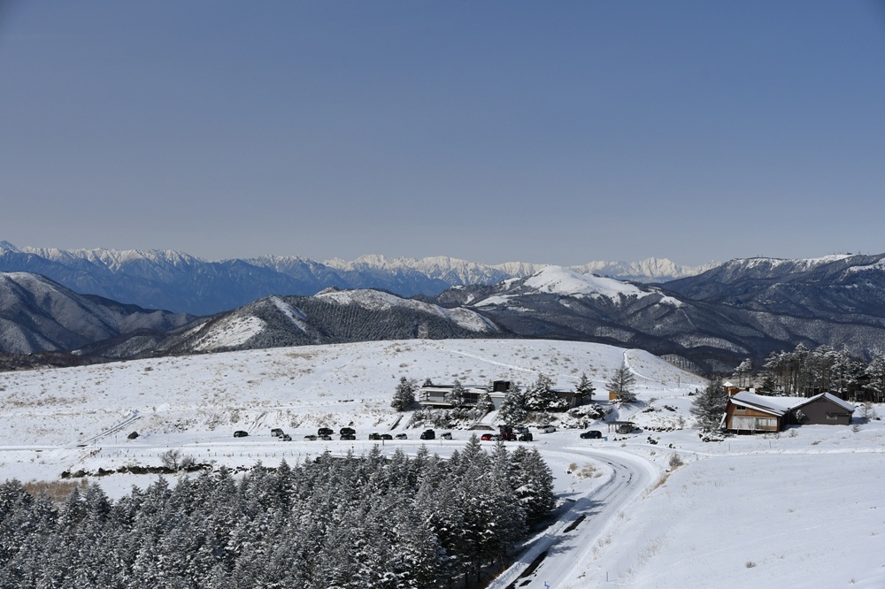 雪に覆われたなだらかな丘と冠雪している北アルプス