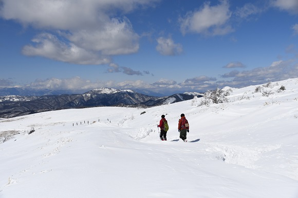 雪の積もった登山道を歩く登山者